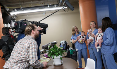 Nurses with babies being filmed
