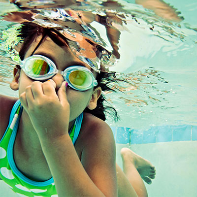 Underwater photo of child swimming in pool