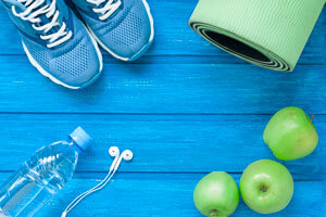 water bottle, workout shoes, apples, and yoga mat