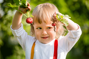 child with fresh picked radishes