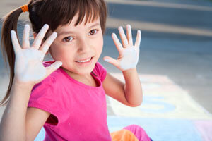 Little girl with chalk on hands