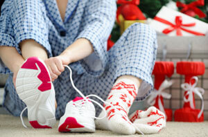 person putting sneakers on near christmas presents